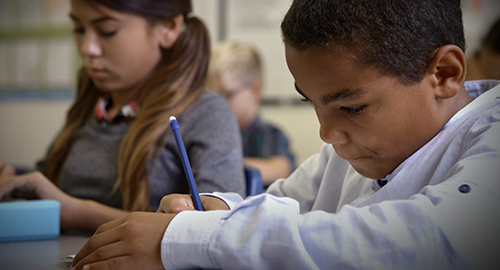 Children in class taking notes