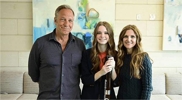 Mike Rowe with two women, one with a bassoon