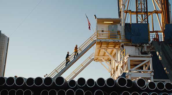 Oil workers climb the stairs to a platform