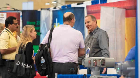 People chatting with sponsor in a booth