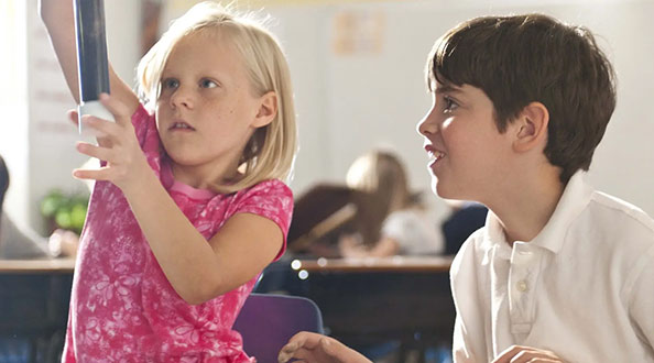 Two kids doing an experiment in a classroom