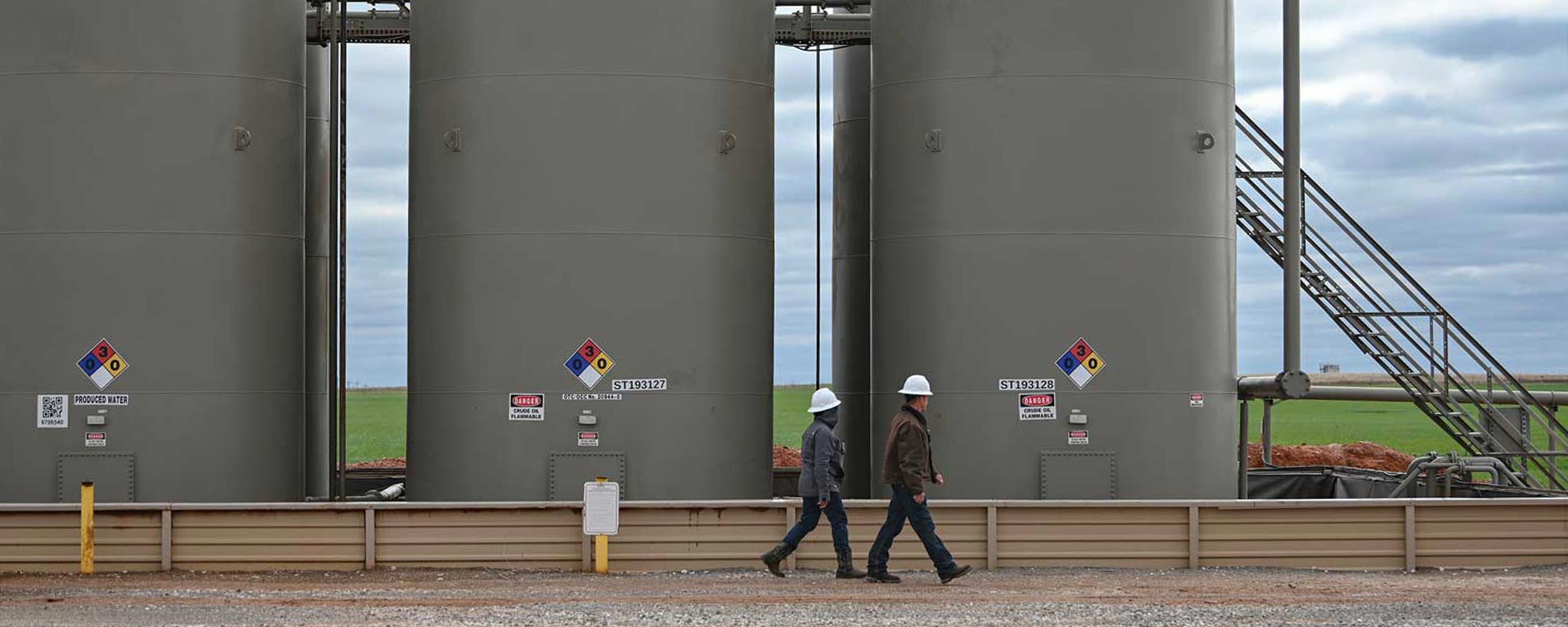 Technicians walking by large tanks