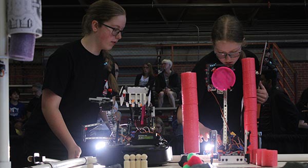 Two students working at a robotics workshop