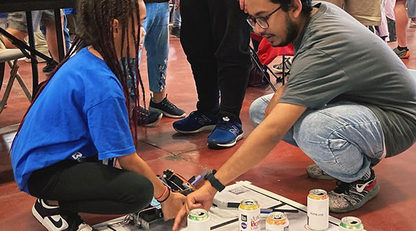 Instructor helping student with a Botball experiment