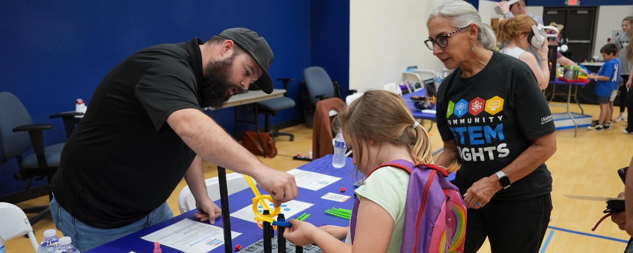 Volunteers and child working on a Community STEM night project