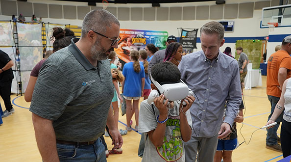 Volunteers working with a child using a virtual reality headset