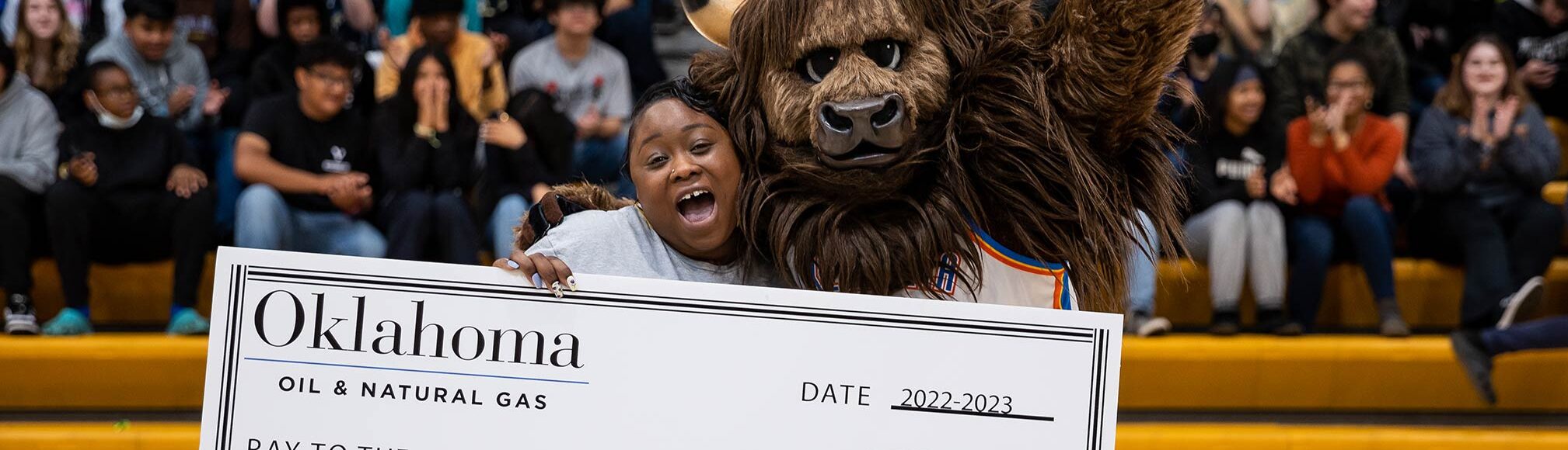 Top Teacher of 2022-2023 in arena with mascot