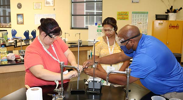 Three workshop participants do a science experiment