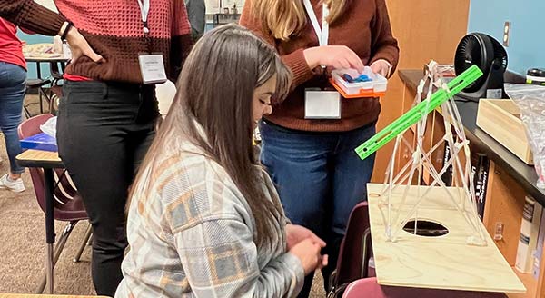 Workshop participants work with structures made out of straws