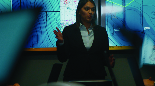 Female leading a group meeting with maps on screen