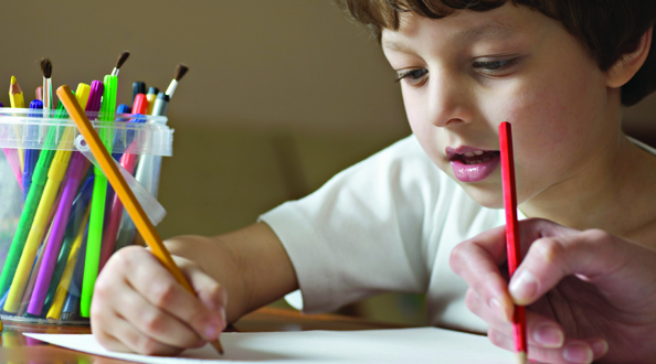 Boy writing on paper with a pencil