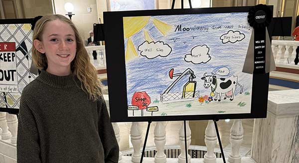 Well site safety winner with artwork depicting a cow on a farm with an oil well in the distance