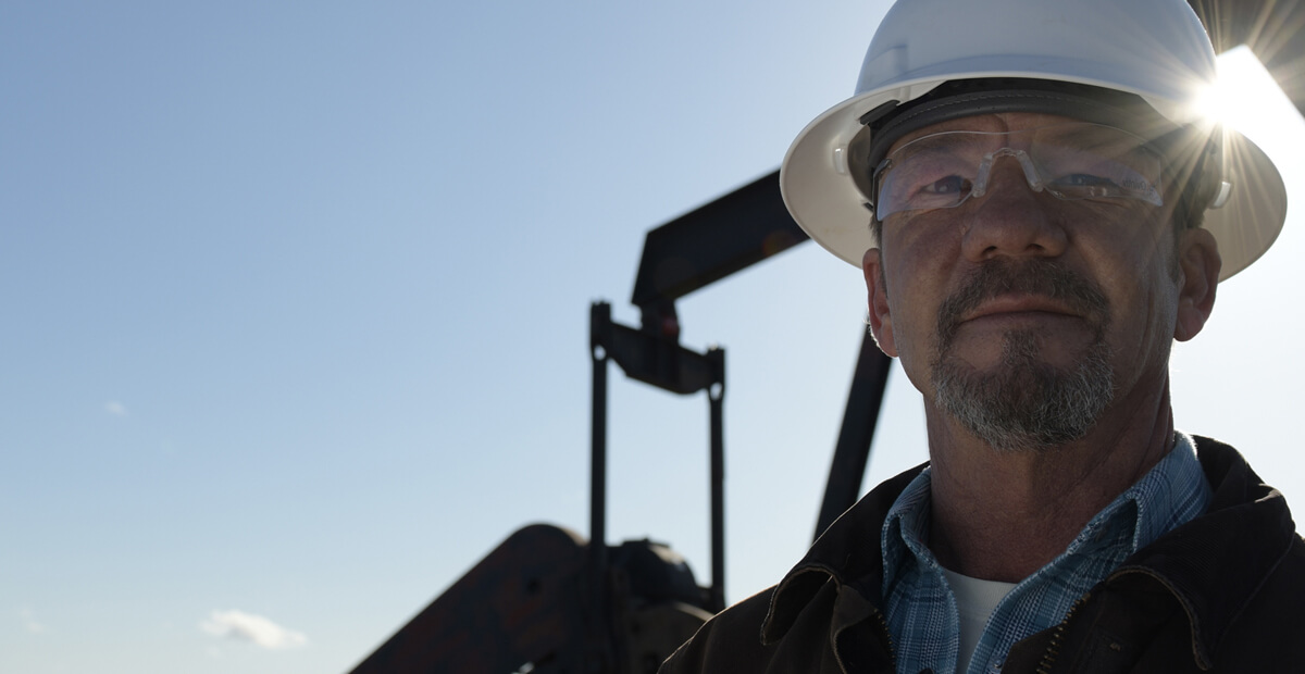 Oil technician with oil pump in background