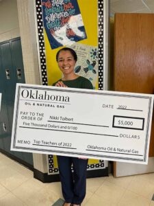 Nikki Tolbert, a Top Teacher of 2022, holds an award check