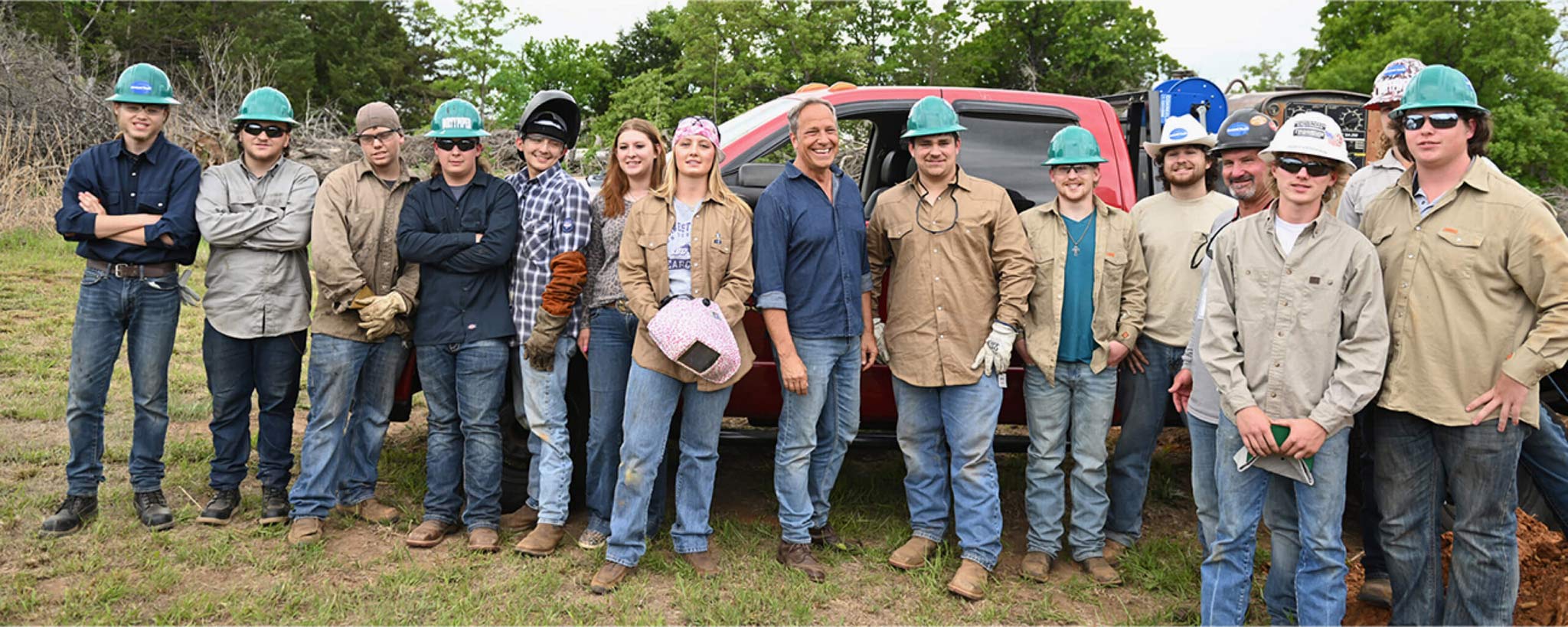 Group of students with Mike Rowe standing in front of a work truck